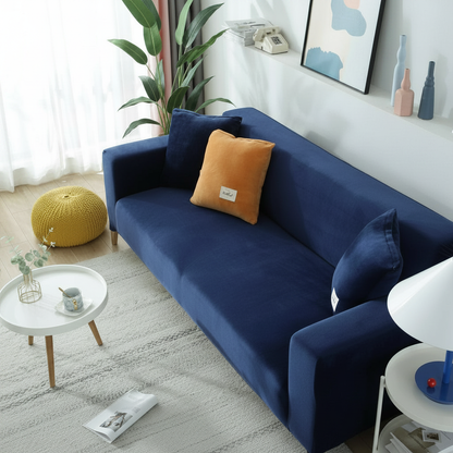 Navy blue velvet full stretch sofa slipcover fitted on a 3-seater couch in a bright modern living room