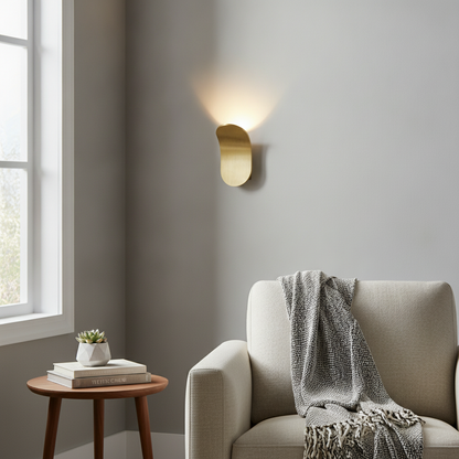 KallioLight gold metal wall sconce mounted in a modern living room lifestyle
