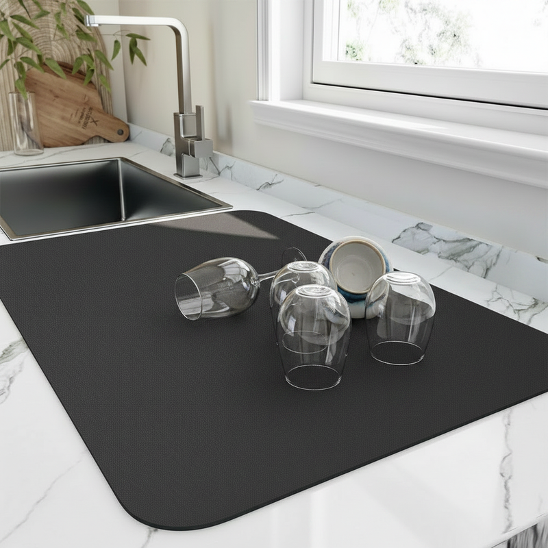 Diatomite quick-dry dish mat in use beside the kitchen sink with glasses drying